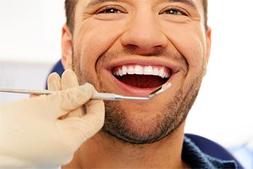 Man smiling getting treated for gum disease, Garran ACT