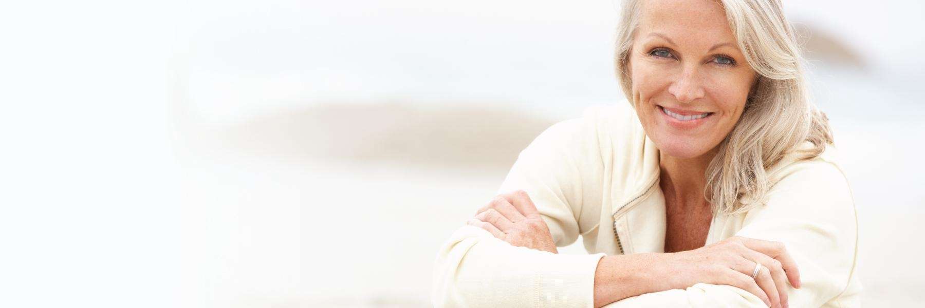 Older woman sitting and smiling after dental implants, Garran ACT