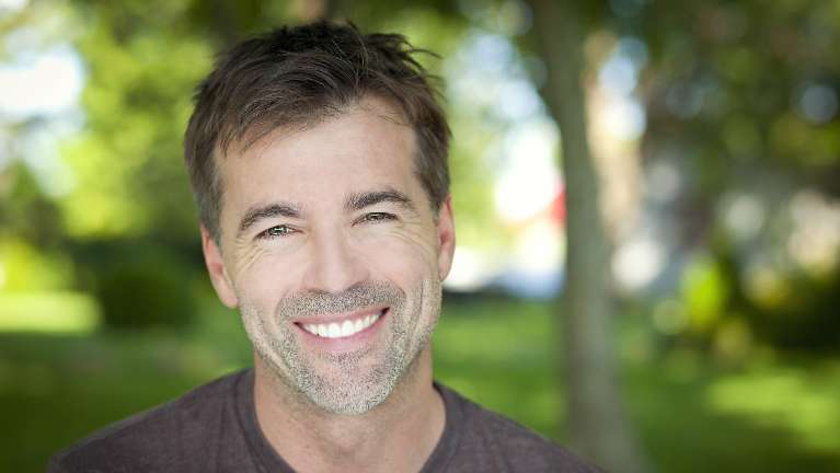Older man smiling after dental implants, Garran ACT
