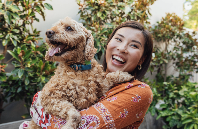 woman smiling holding a dog