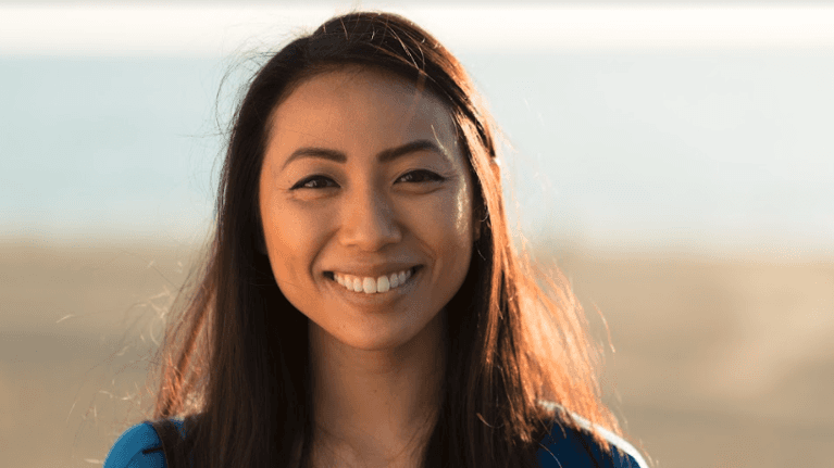 Asian woman smiling, managing her dental pain at home, Garran ACT
